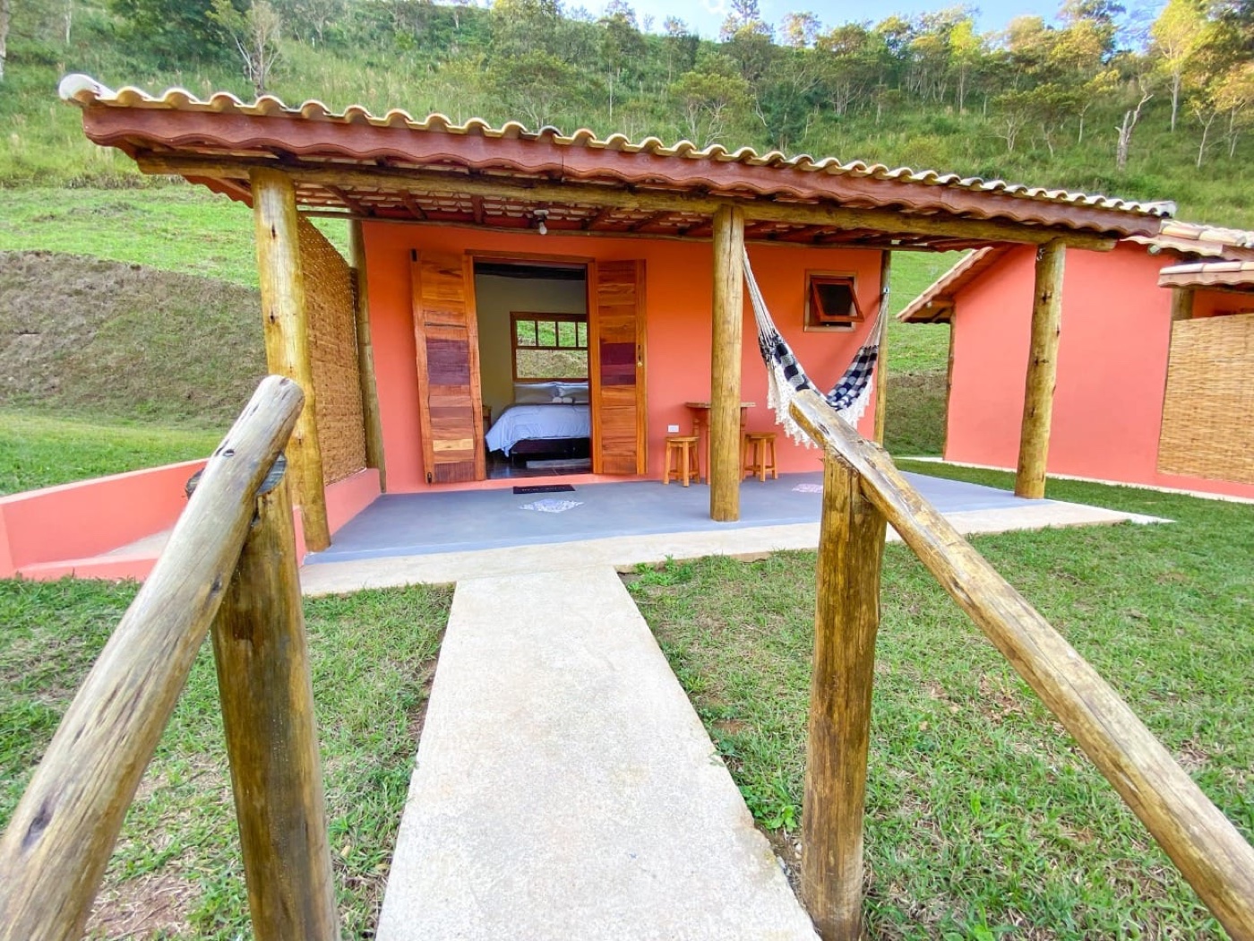 Chalé com varanda e rede de frente para o vale